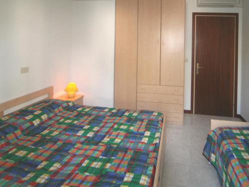 1 dormitorio con 1 cama con una manta colorida en Patrizia, en Lignano Sabbiadoro