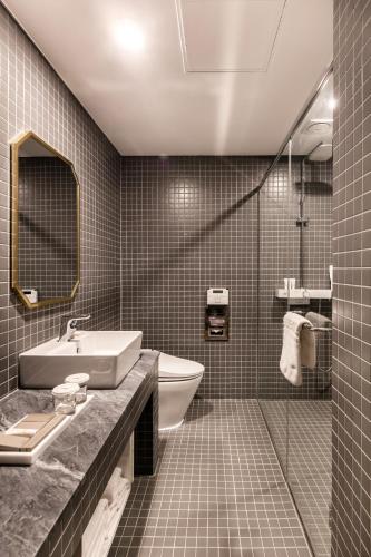 a bathroom with a sink and a tub and a toilet at WesternLife Hotel in Iksan