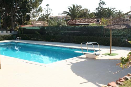 a swimming pool with a chair and an umbrella at Verdemare Sardegna Uno in Villasimius