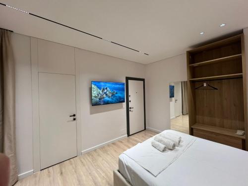 een slaapkamer met een bed en een tv aan de muur bij Central Tirana Apartments in Tirana