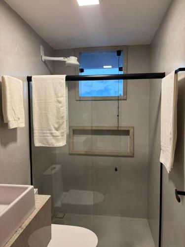 een badkamer met een douche met een glazen deur bij Flat com vista mar in Mucuri