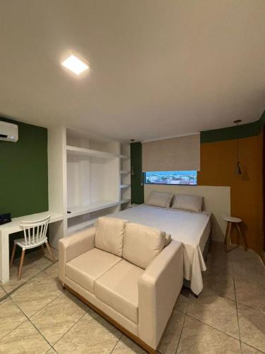 een slaapkamer met een bed, een bank en een bureau bij Flat com vista mar in Mucuri