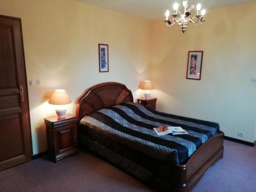 ein Schlafzimmer mit einem Bett mit zwei Nachttischen und zwei Lampen in der Unterkunft Charming Chalet with Swimming Pool in Quend in Quend