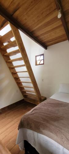 a bedroom with a bed in a room with wooden ceilings at Do Alto da Montanha Pousada in Vale do Capao