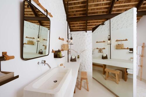 北冲Roukh Kiri Khaoyai, The Centara Collection的带白色浴缸和水槽的浴室