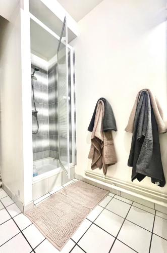 a bathroom with a shower and towels on the wall at Studio Cosy proche CHU in Amiens