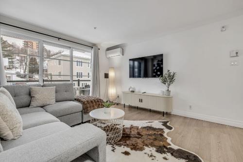 ein Wohnzimmer mit Sofa und Tisch in der Unterkunft INITIAL - CAMPAGNARD - Chutes-Montmorency in Boischâtel