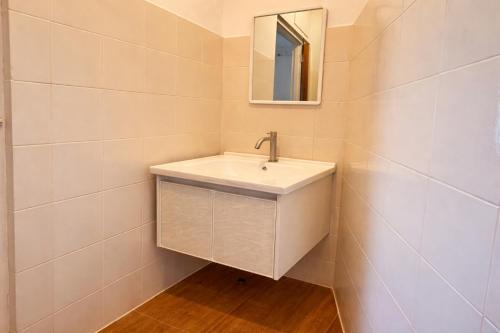 een badkamer met een witte wastafel en een spiegel bij Redang Divers Resort in Redang Island