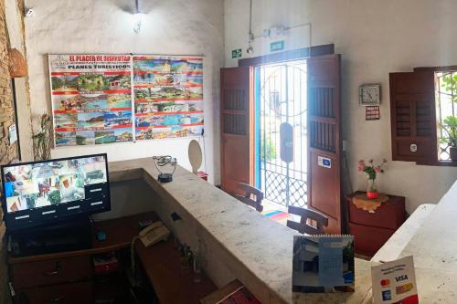 una stanza con un bancone con una tv e una scrivania di Hotel Casa de Sarah a Santa Marta