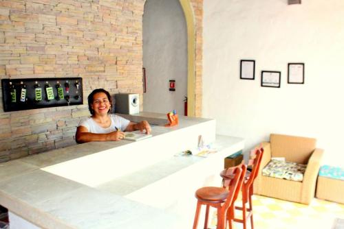 una donna seduta al bancone di una cucina di Hotel Casa de Sarah a Santa Marta