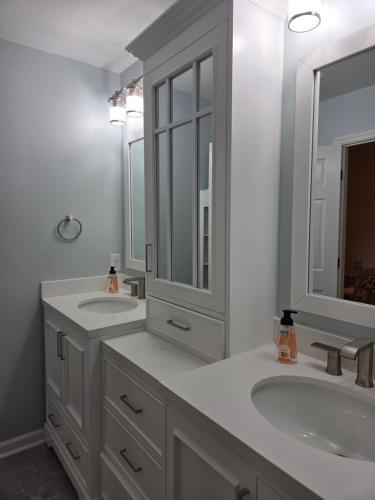 a white bathroom with two sinks and a mirror at Walk to Augusta National with Pool, Housekeeper, and Utilities Included in Augusta