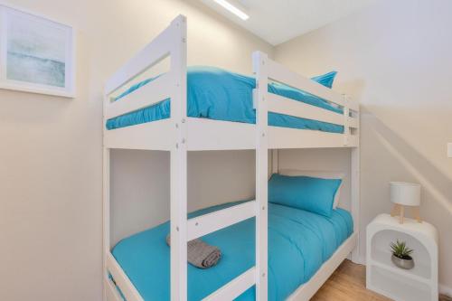 een wit stapelbed in een kamer met blauwe kussens bij Bel R Vista in Gold Coast