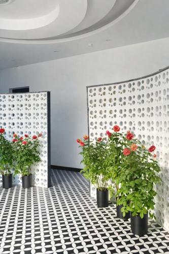 a room with three potted plants and red flowers at Habibi Hotel in Sóc Sơn