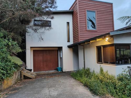 een wit en rood huis met een garage bij Ke's home in Wellington