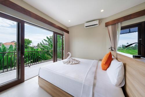 a bedroom with a bed and a balcony at Uma Dauh Villa - Cemagi in Munggu