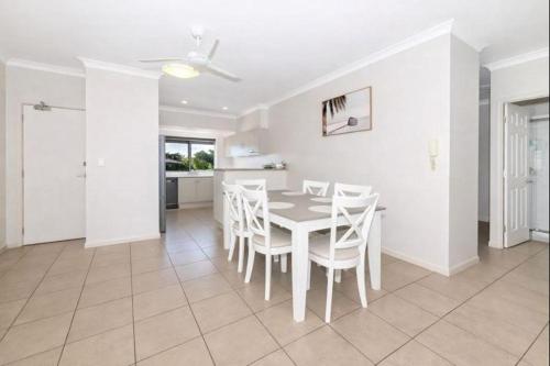 een witte eetkamer met een tafel en stoelen bij Peaceful on Percy West End Townsville in North Ward