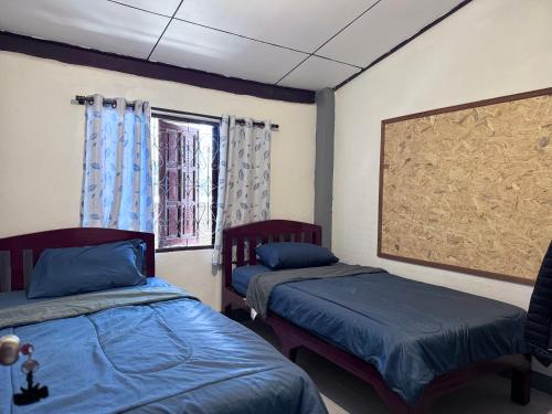 een kamer met twee bedden en een raam bij Baboo Guesthouse in Chiang Dao