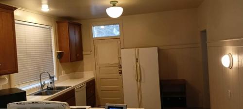 a kitchen with a refrigerator and a sink and a window at Historic Reno Home in Reno