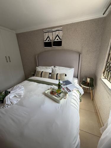 a large white bed with a tray of food on it at Shayas Haven in Thohoyandou