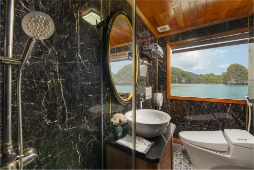 een badkamer met een wastafel, een toilet en een spiegel bij Beka Cruise 