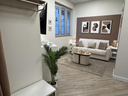 a living room with a couch and a table at Marianne l'Essentiel in Bergerac