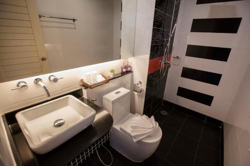 a bathroom with a white toilet and a sink at The Elysium Residence - SHA Extra Plus in Chalong 