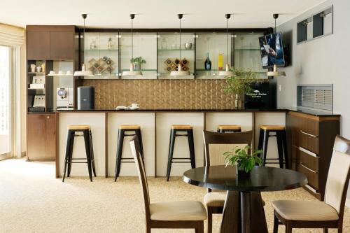 a kitchen with a bar with stools and a table at Oakwood Residence Aoyama Tokyo in Tokyo