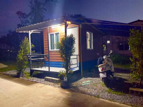 een klein huis met een scooter ervoor geparkeerd bij Lamai Home 3 in Ko Yao Noi
