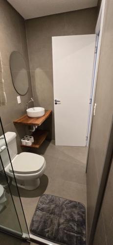 een badkamer met een wit toilet en een wastafel bij Eco Isla GuestHouse in Florianópolis