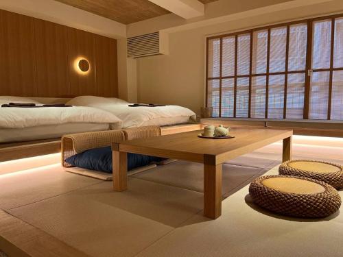 a room with two beds and a table in a room at Hotel Matoma in Tokyo