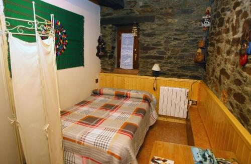 een slaapkamer met een bed en een stenen muur bij Casa de Abril 1 in San Cristóbal de Valdueza