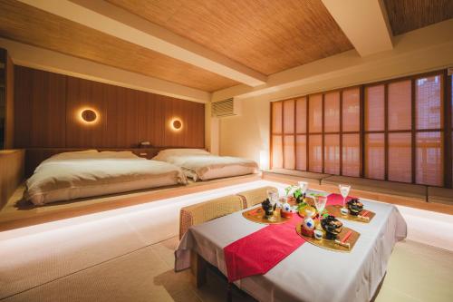 a bedroom with two beds and a table with food on it at Hotel Matoma in Tokyo