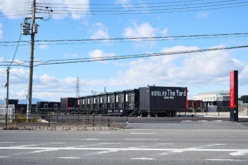 a train is on the tracks near a street at HOTEL R9 The Yard Gamohino in Hino