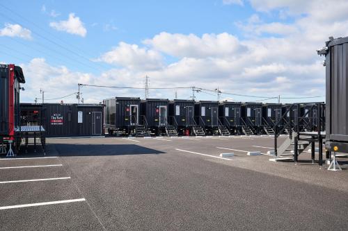 a parking lot with rows of black shipping containers at HOTEL R9 The Yard Gamohino in Hino