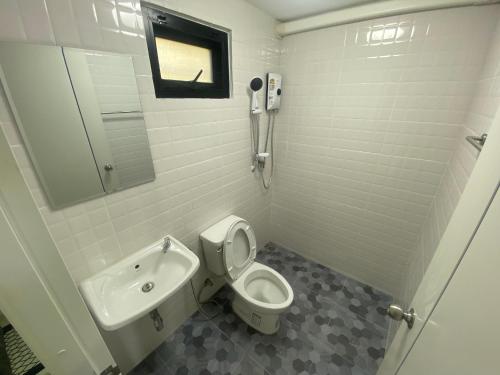 a bathroom with a toilet and a sink at รักกันต์ รีสอร์ท in Ban Sakat Namman