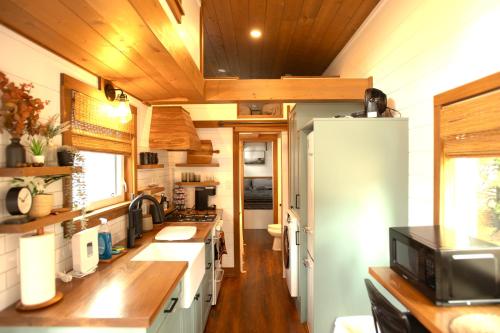 Tiny Rustic at Yosemite Gateway في غروفلاند: مطبخ في منزل صغير بسقوف خشبية