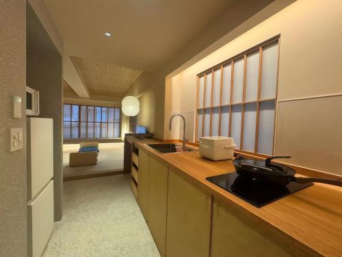 a kitchen with a counter with a sink and a refrigerator at Hotel Matoma in Tokyo