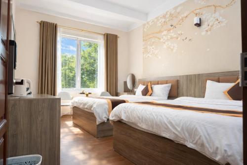 ein Hotelzimmer mit zwei Betten und einem Fenster in der Unterkunft Phương Anh Villa 3 in Bắc Ninh