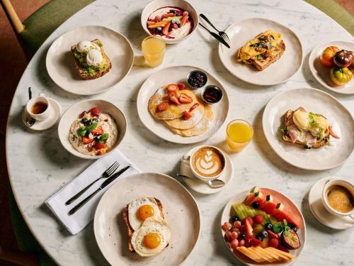 a table with plates of breakfast food on it at Novotel Melbourne Airport in Melbourne