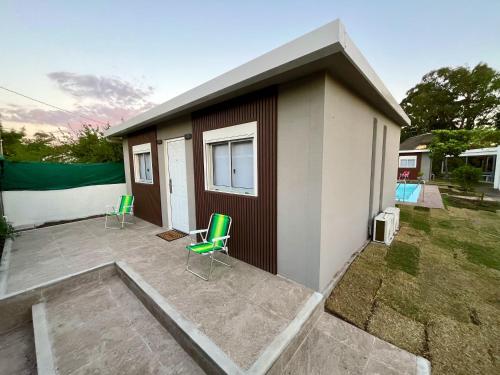 una piccola casa con sedie verdi su un patio di Coralma a La Floresta