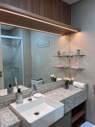 ein Badezimmer mit Waschbecken und großem Spiegel in der Unterkunft Rooftop com vista para o mar in Fortaleza