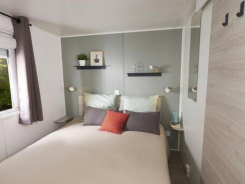 ein kleines Schlafzimmer mit einem Bett in einem Zimmer in der Unterkunft Mobil-home confortable avec terrasse à Saint-Gérons - API-1-52-1311 in Saint-Étienne-Cantalès