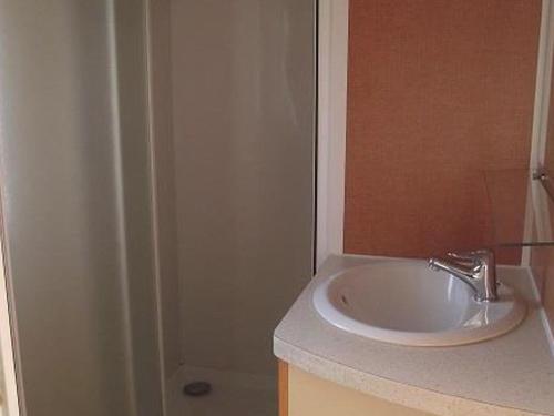 a bathroom with a sink and a shower at Mobil-home confortable avec terrasse à La Couarde - API-1-52-1305 in Saint-Nicolas des Eaux