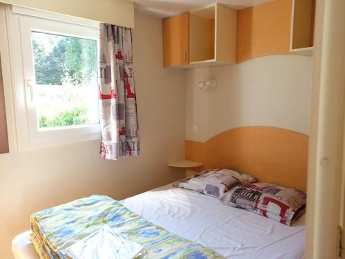 a small bedroom with a bed and a window at Mobil-home confortable avec terrasse à La Couarde - API-1-52-1305 in Saint-Nicolas des Eaux