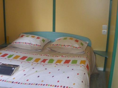 een bed met kussens en een boek erop bij Chalet avec Terrasse pour 4 Pers. - API-1-52-1306 in Saint-Nicolas