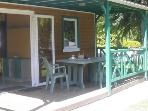 een afgeschermde veranda met een tafel en stoelen bij Chalet avec Terrasse pour 4 Pers. - API-1-52-1306 in Saint-Nicolas