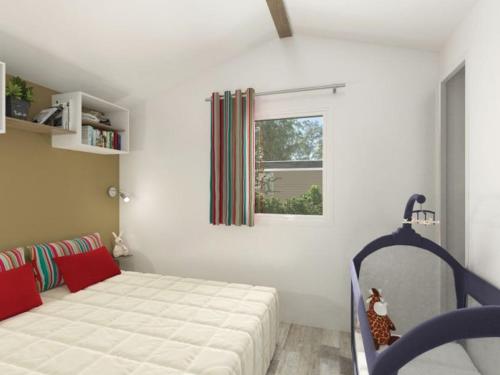 ein Schlafzimmer mit einem Bett und einem Fenster in der Unterkunft Mobil-home 27m² à Saint-Gérons avec terrasse - API-1-52-1316 in Saint-Étienne-Cantalès