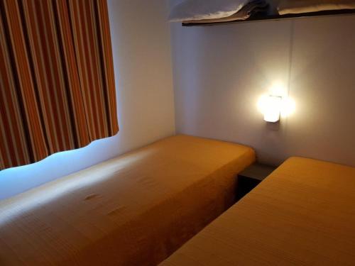 En eller flere senge i et værelse på Mobil home - Terrasse à Bieuzy - API-1-52-1304