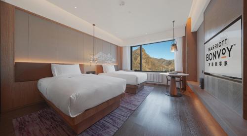 a hotel room with two beds and a window at Courtyard by Marriott Chongli in Zhangjiakou