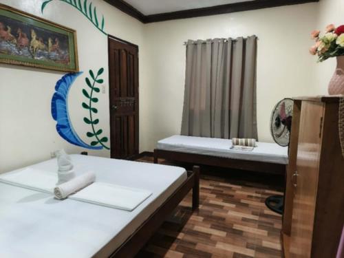Una sala de estar con dos camas y una ventana. en Nay Nilda Tourist Inn, en Itaytay